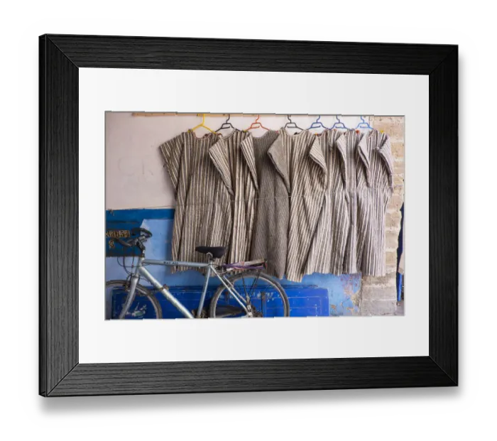 Framed Print : North Africa, Morocco, Essaouira, djeallbas hanging on wall next to bicycle Framed Print : North Africa, Morocco, Essaouira, djeallbas hanging on wall next to bicycle