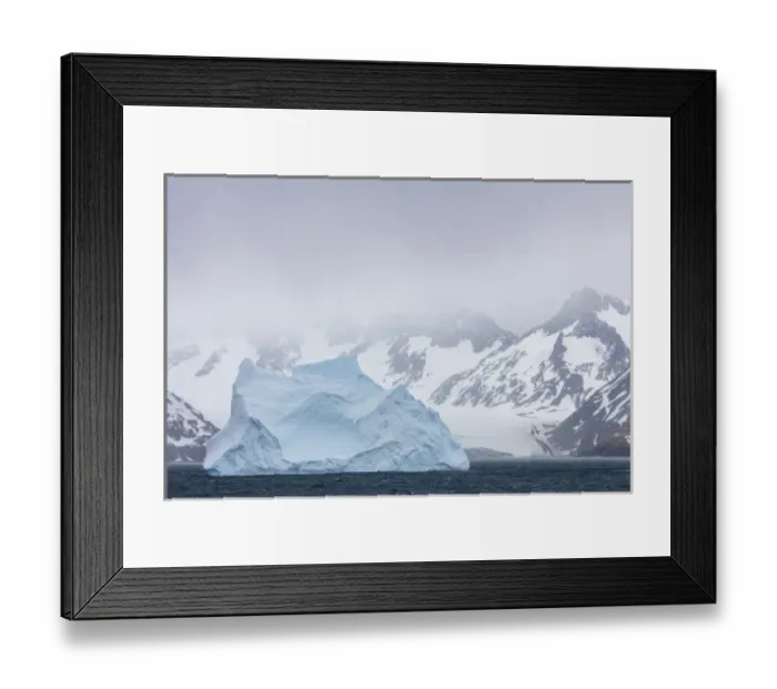 Framed Print : South Georgia Island. Large iceberg floats past mountains