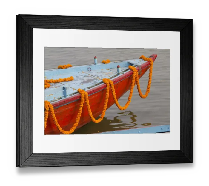 Framed Print : India, Uttar Pradesh, Varanasi. garlands of marigold adorn a small boat headed out Framed Print : India, Uttar Pradesh, Varanasi. garlands of marigold adorn a small boat headed out