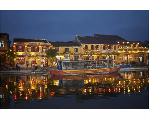 Boat and restaurants reflected in Thu Bon River at dusk, Hoi An (UNESCO World Heritage Site)