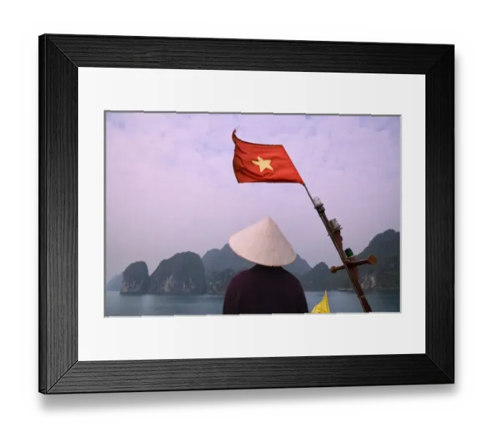 Framed Print : Girl with conical hat on a junk boat with national flag and karst islands in Halong Bay Framed Print : Girl with conical hat on a junk boat with national flag and karst islands in Halong Bay