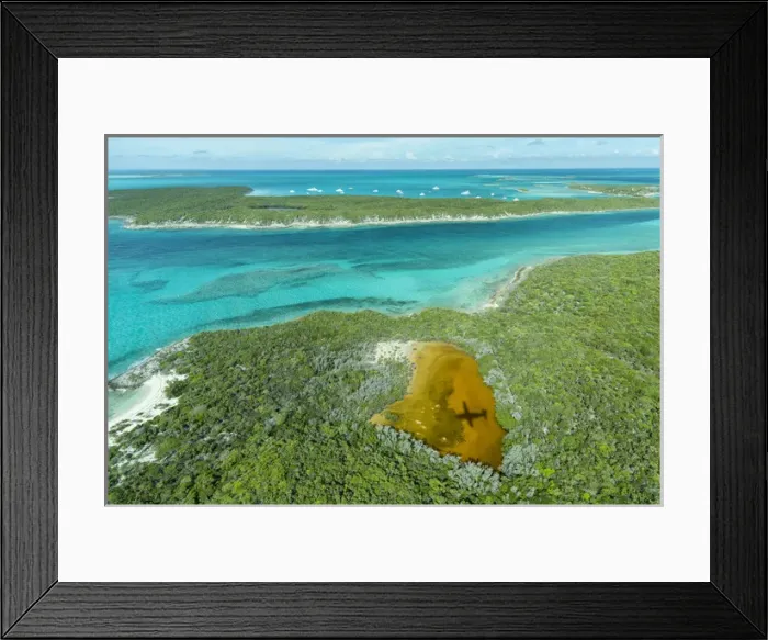 Framed Print : Aerial photo looking down at the airplanes shadow and clear tropical water