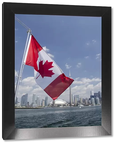 Canada, Ontario, Toronto. Lake Ontario city skyline view with CN Tower & Canadian flag