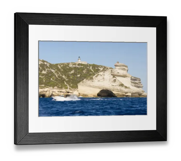 Framed Print : Europe, France, Corsica, Bonifacio. Boat passes Capo Pertusato lighthouse