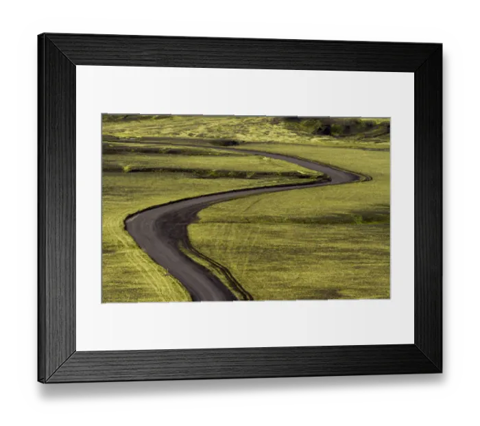 Framed Print : Europe, Iceland. Black dirt road curves through green countryside Framed Print : Europe, Iceland. Black dirt road curves through green countryside