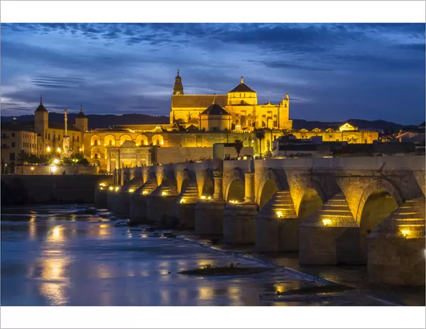 Spain, Andalusia. Cordoba. The Roman bridge across the Guadalquivir river at dusk