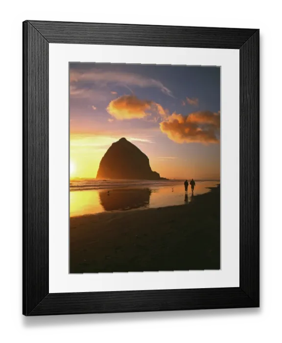 Framed Print : USA, Oregon, Cannon Beach. Couple walking beside Haystack Rock at sunset. Credit as
