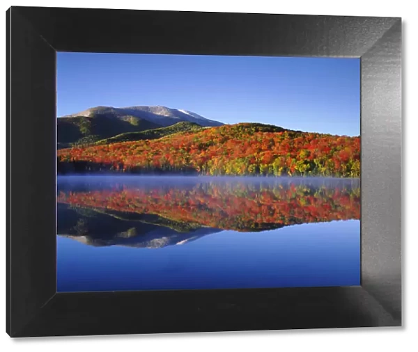 USA; New York; Snow Capped Algonquin Peak and autumn colors relecting in Heart Lake