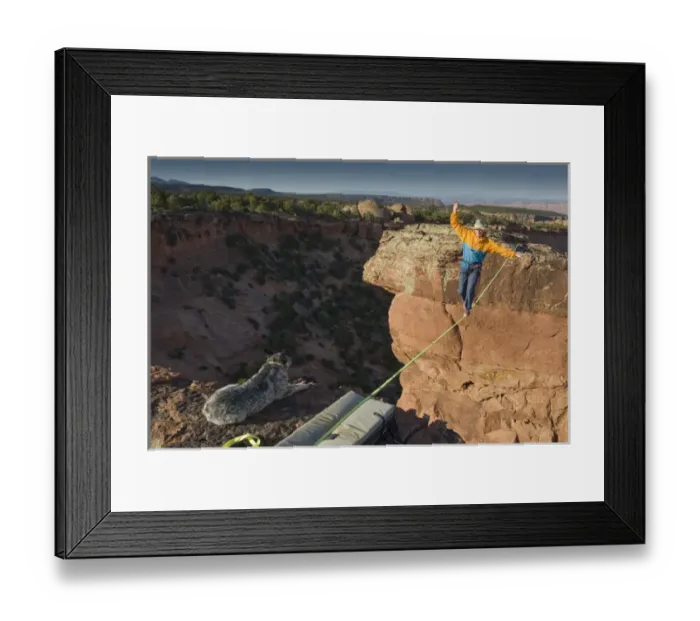 Framed Print : Larry Harpe highlining (slacklining) between Navaho Sandstone Towers with his dog watching