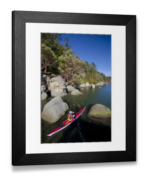Framed Print : USA, Washington State. Woman sea kayaker paddles between rocks in Chuckanut Bay near Bellingham Framed Print : USA, Washington State. Woman sea kayaker paddles between rocks in Chuckanut Bay near Bellingham