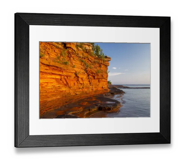 Framed Print : Layered sandstone cliffs and sea caves at sunrise on Devils Island in the Apostle