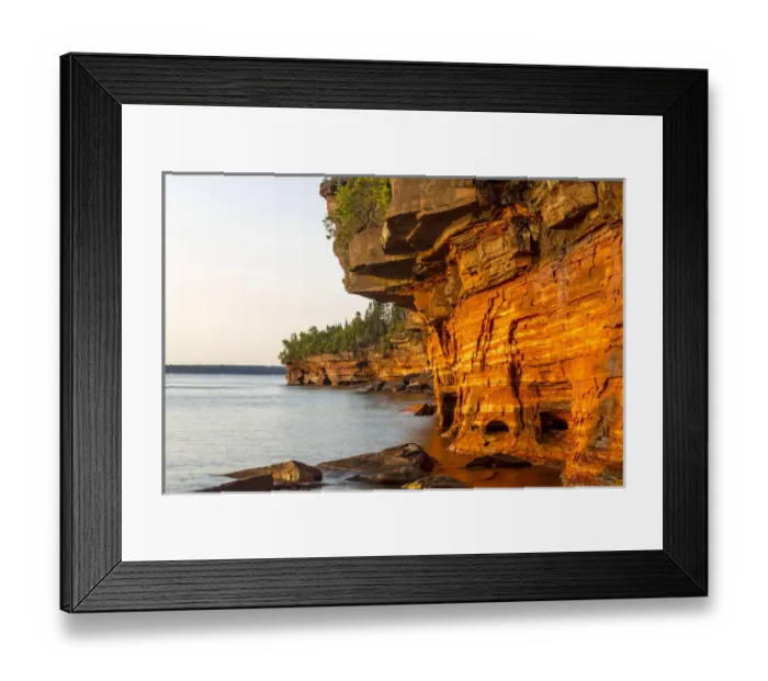 Framed Print : Layered sandstone cliffs and sea caves at sunrise on Devils Island in the Apostle