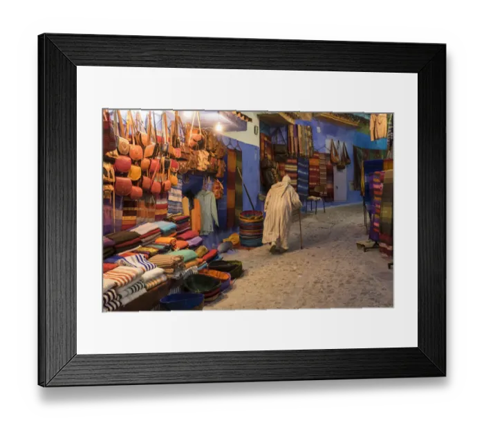 Framed Print : Africa, Morocco. An elderly man walks past tourist shops along a street in the blue Framed Print : Africa, Morocco. An elderly man walks past tourist shops along a street in the blue