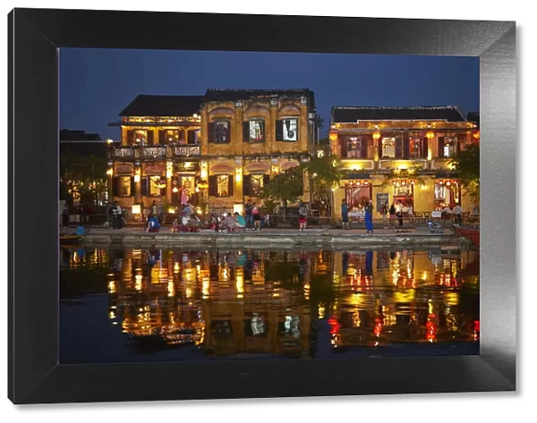 Restaurants and tourists reflected in Thu Bon River at dusk, Hoi An (UNESCO World Heritage Site)