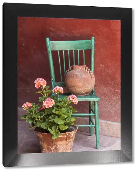 Mexico, San Miguel de Allende. Geraniums, flowerpots and chair decorate an entrance