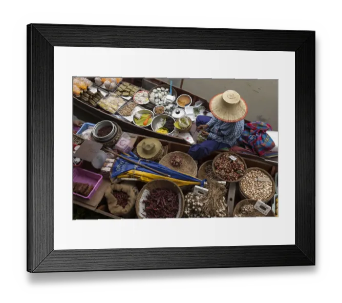 Framed Print : Thailand, Amphawa Floating Market. Woman prepares food for customer in her dugout canoe shop
