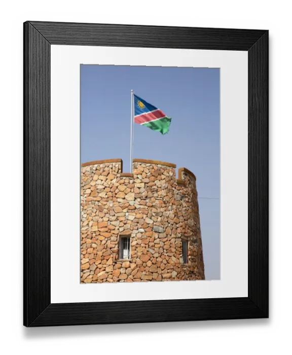 Framed Print : Africa, Namibia, Etosha National Park. Namibian flag flies over brick tower at park entrance