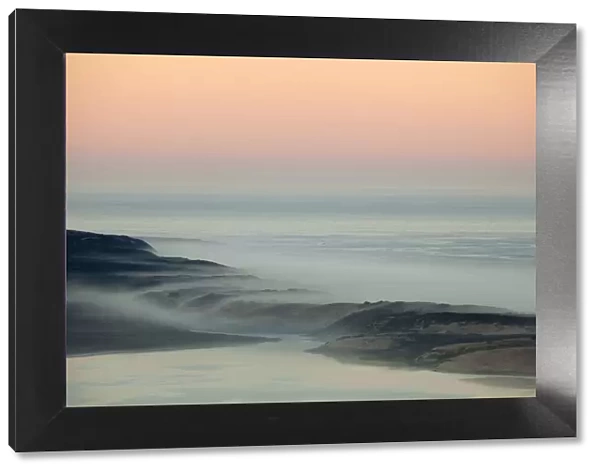 USA, California, Moro Bay. Morning fog on sand dunes and ocean