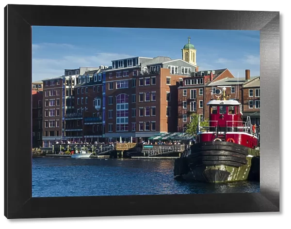 USA, New Hampshire, Portsmouth, waterfront buildings with tugboat