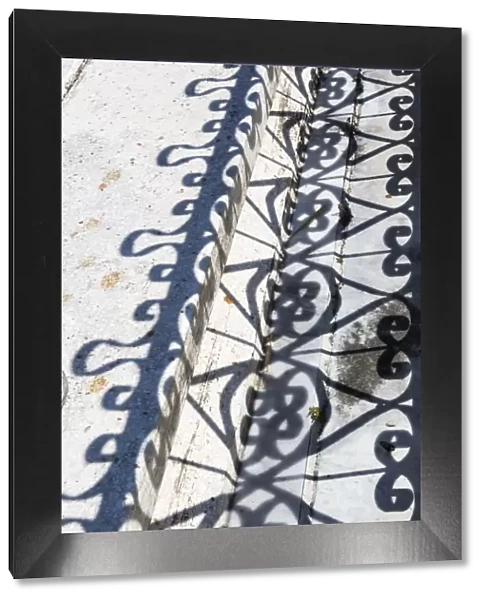 Cuba, Havana, Colon Cemetery. Wrought iron fence and shadow