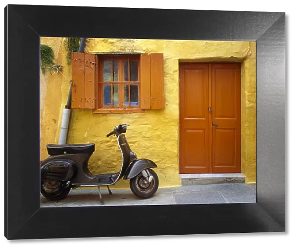 Greece, Rhodes. Vespa motorbike and colorful house exterior
