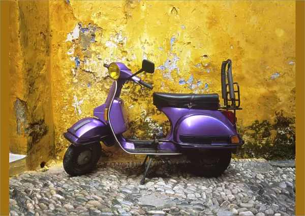 Greece, Rhodes. Vespa motorbike and colorful house exterior