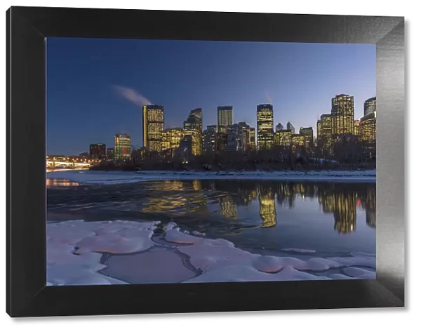 Winter city skyline reflects in the Bow River in Calgary, Alberta, Canada