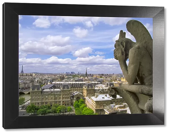 Gargoyle on the roof of Notre Dame cathedral looks out over Paris, France