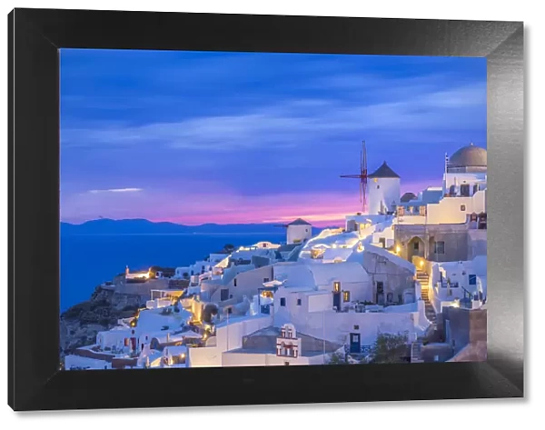 Europe, Greece, Oia. Greek Orthodox church and village at sunset