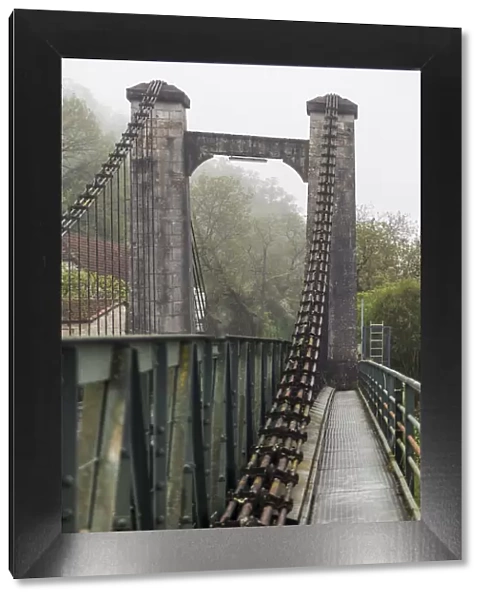 France, Cajarc. Early morning fog on the iron bridge over the Lot River