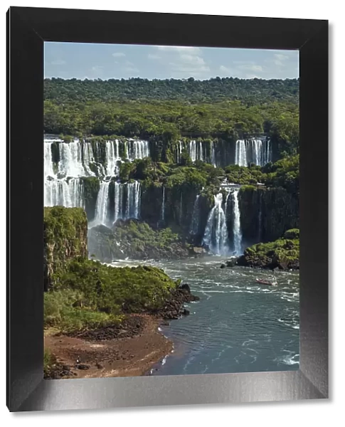 Iguazu Falls on Argentina side and tourist boat on Iguazu River, Brazil and Argentina