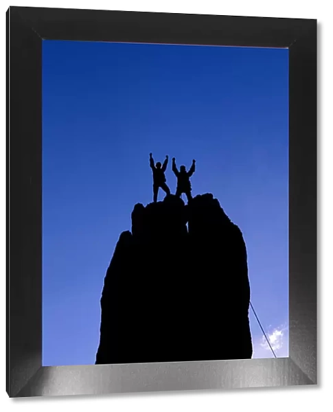 Silhouetted climbers celebrating on the summit of Eichorn Pinnacle, Yosemite National Park