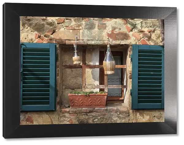 Italy, Monteriggioni. Stone wall, curtained window with blue shutters