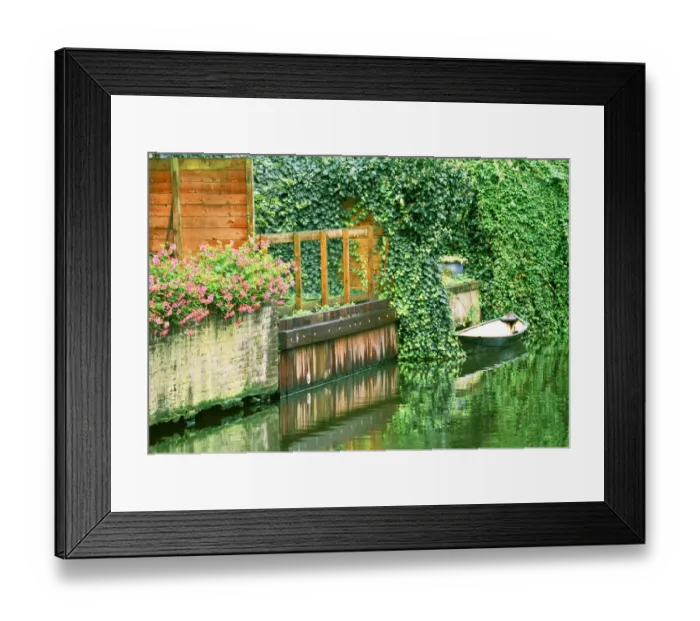 Framed Print : Small boat tied up in a canal next to a garden in Amsterdam Framed Print : Small boat tied up in a canal next to a garden in Amsterdam