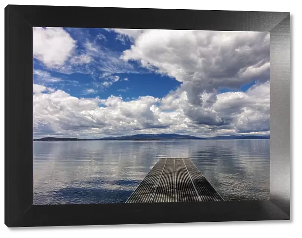 Dock reaches out into Skidoo Bay in Flathead Lake near Polson, Montana, USA