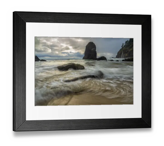 Framed Print : Swirling water around rocks on a beach