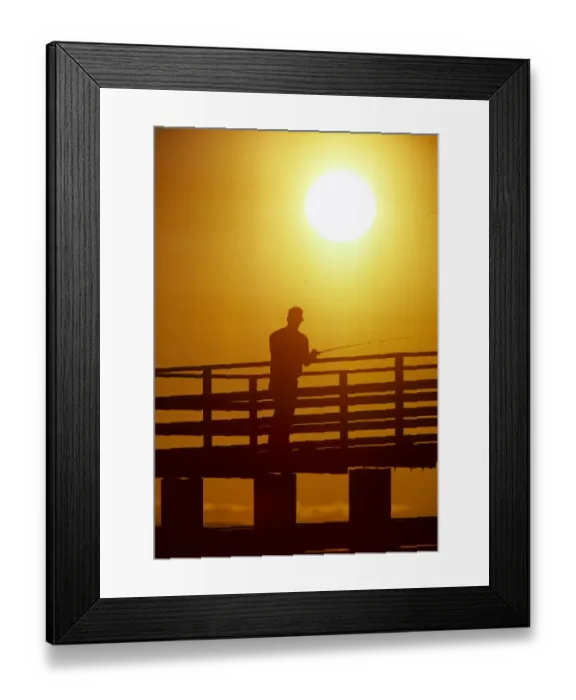 Framed Print : Silhouette of man fishing from a pier