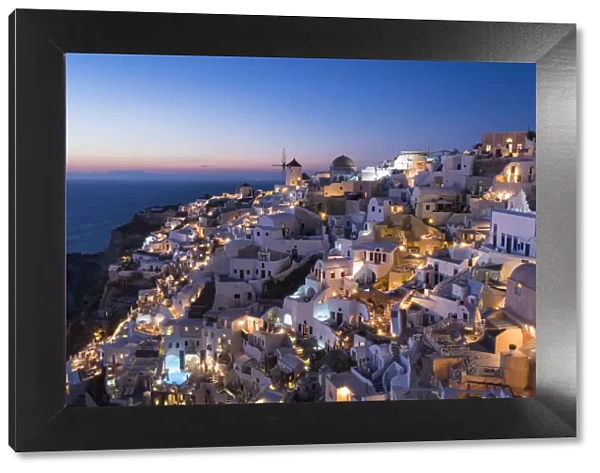 Greece, Santorini. The village of Oia glows in the post-sunset light as the town s