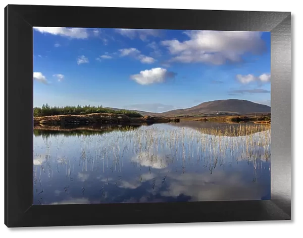 Small lake reflecting clouds near Clifden, Ireland