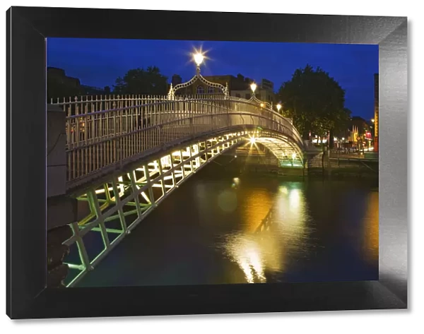 Ireland, Dublin. Ha Penny Bridge and River Liffey lit at night