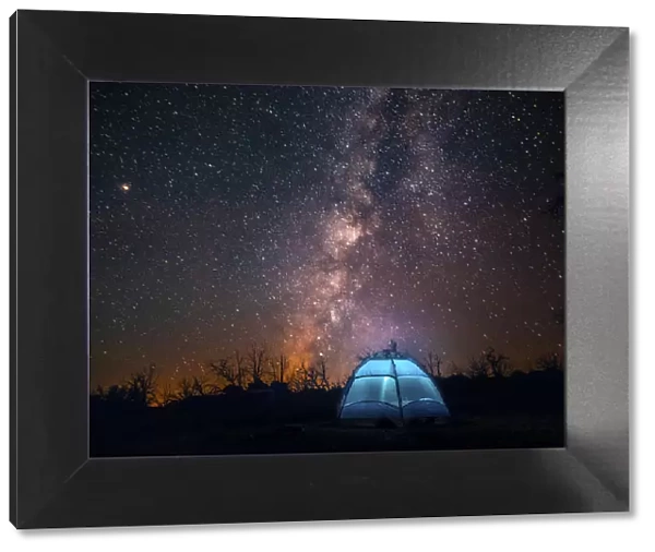 USA, California, Mojave Desert. An illuminated tent against a starry sky and the Milky Way