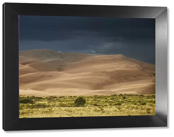 USA, Colorado, Great Sand Dunes National Park. Thunderstorm over sand dunes near sunset
