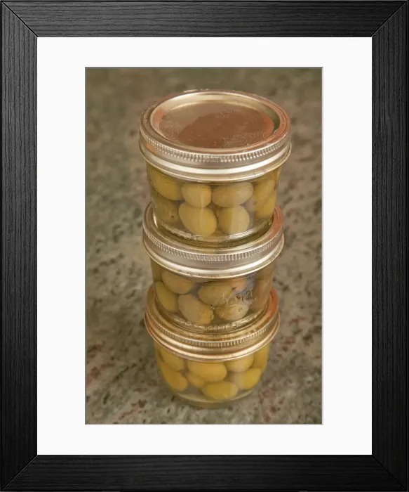 Framed Print : Three jars of home canned olives on a granite countertop in a kitchen