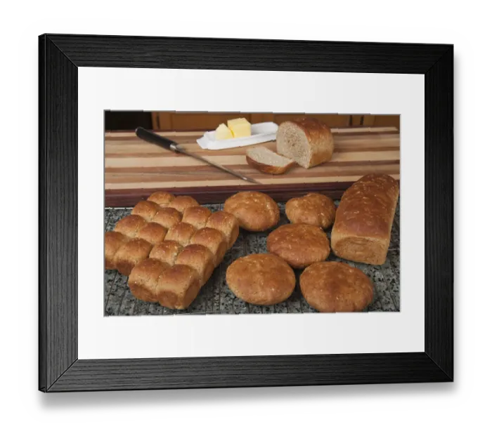 Framed Print : Multigrain rolls, buns and loaf with a slice cut off, with butter and a bread knife Framed Print : Multigrain rolls, buns and loaf with a slice cut off, with butter and a bread knife