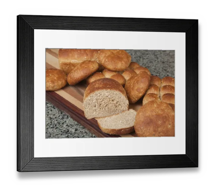 Framed Print : Multigrain rolls, buns and loaf with a slice cut off, on bread board Framed Print : Multigrain rolls, buns and loaf with a slice cut off, on bread board