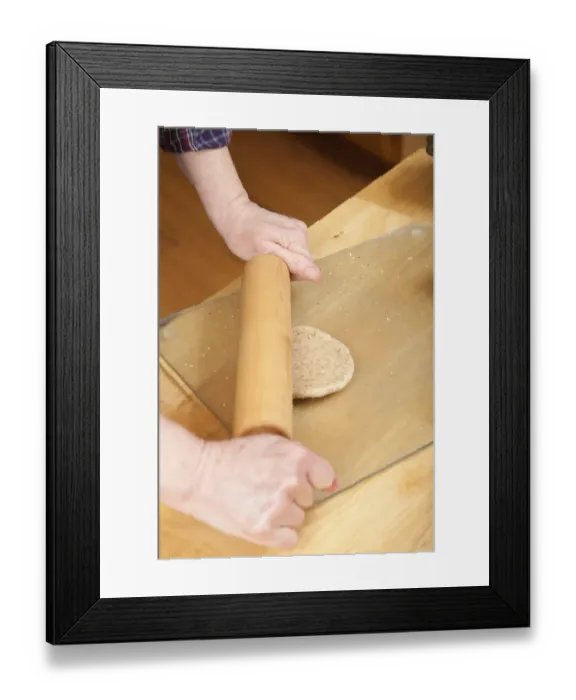 Framed Print : Woman rolling multigrain bread dough into circles to make hamburger buns. (MR) Framed Print : Woman rolling multigrain bread dough into circles to make hamburger buns. (MR)