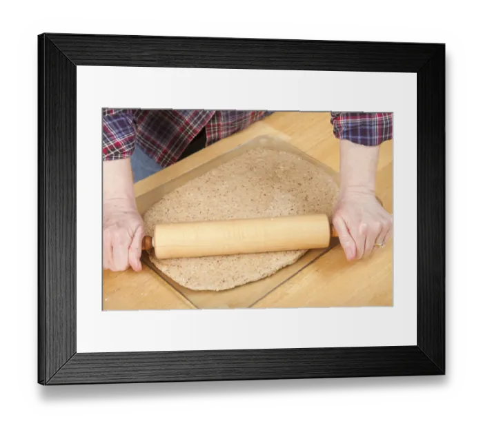 Framed Print : Woman rolling ball of bread dough with a rolling pin to flatten it, prior to forming Framed Print : Woman rolling ball of bread dough with a rolling pin to flatten it, prior to forming