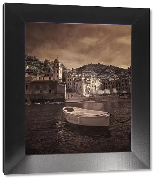 Italy, Vernazza. Infrared image of a boat in the harbor of Vernazza with the church in