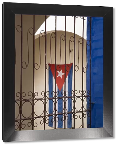 Cuba, Vinales, Cuban flag in courtyard and wrought iron gate