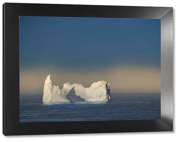 Antarctica, South Georgia Island. Lone iceberg and sunset